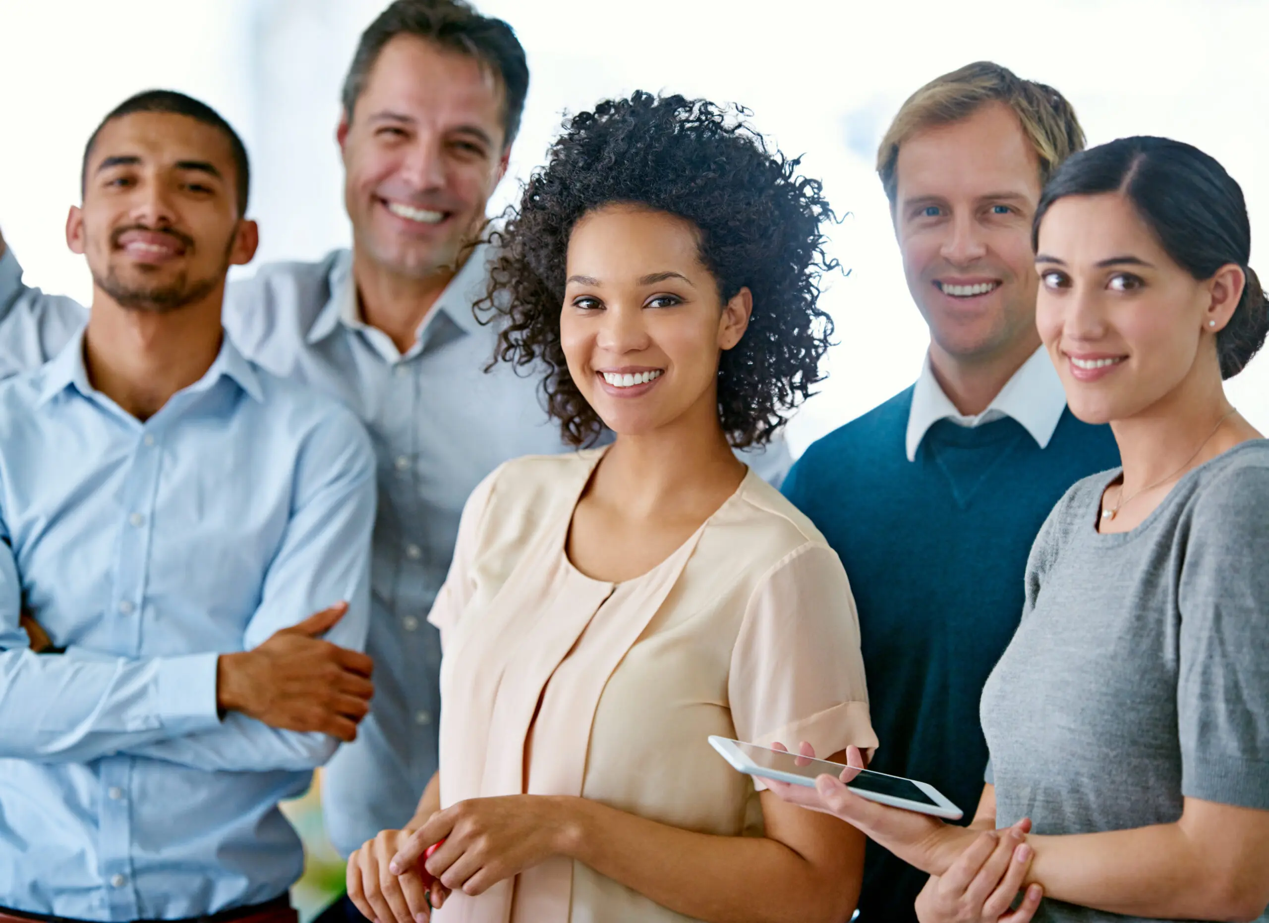 Synergy in practice. Portrait of a group of smiling coworkers standing in anoffice