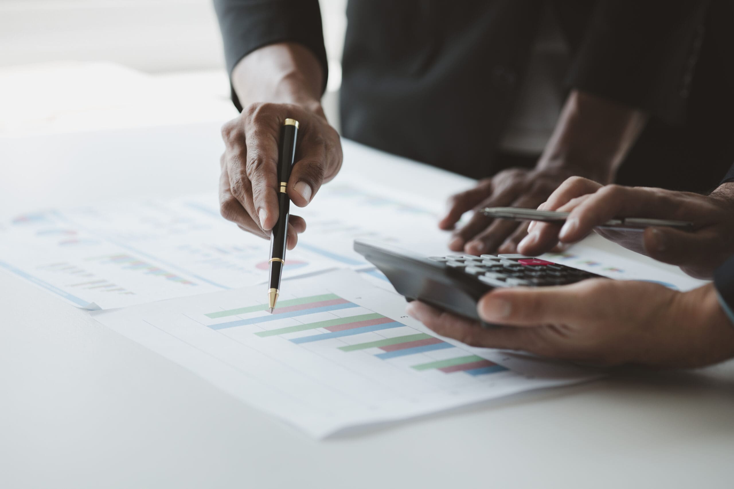 Two businessmen are brainstorming together and reviewing the company financial documents that the finance department has summarized, they are business partners. Business administration concept.